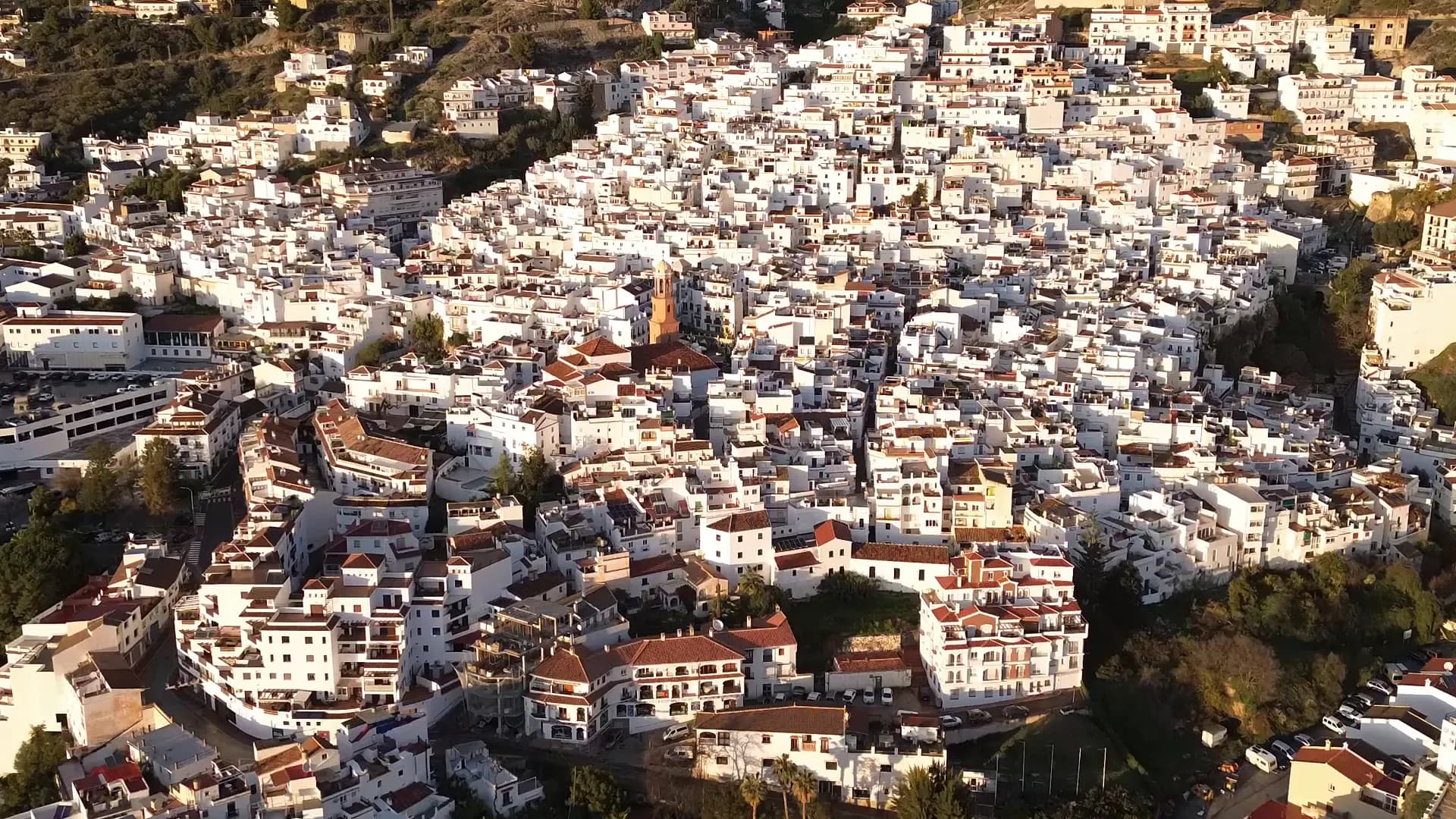 Vista panorámica de un pueblo blanco de la Axarquía, con montañas y vegetación mediterránea al fondo